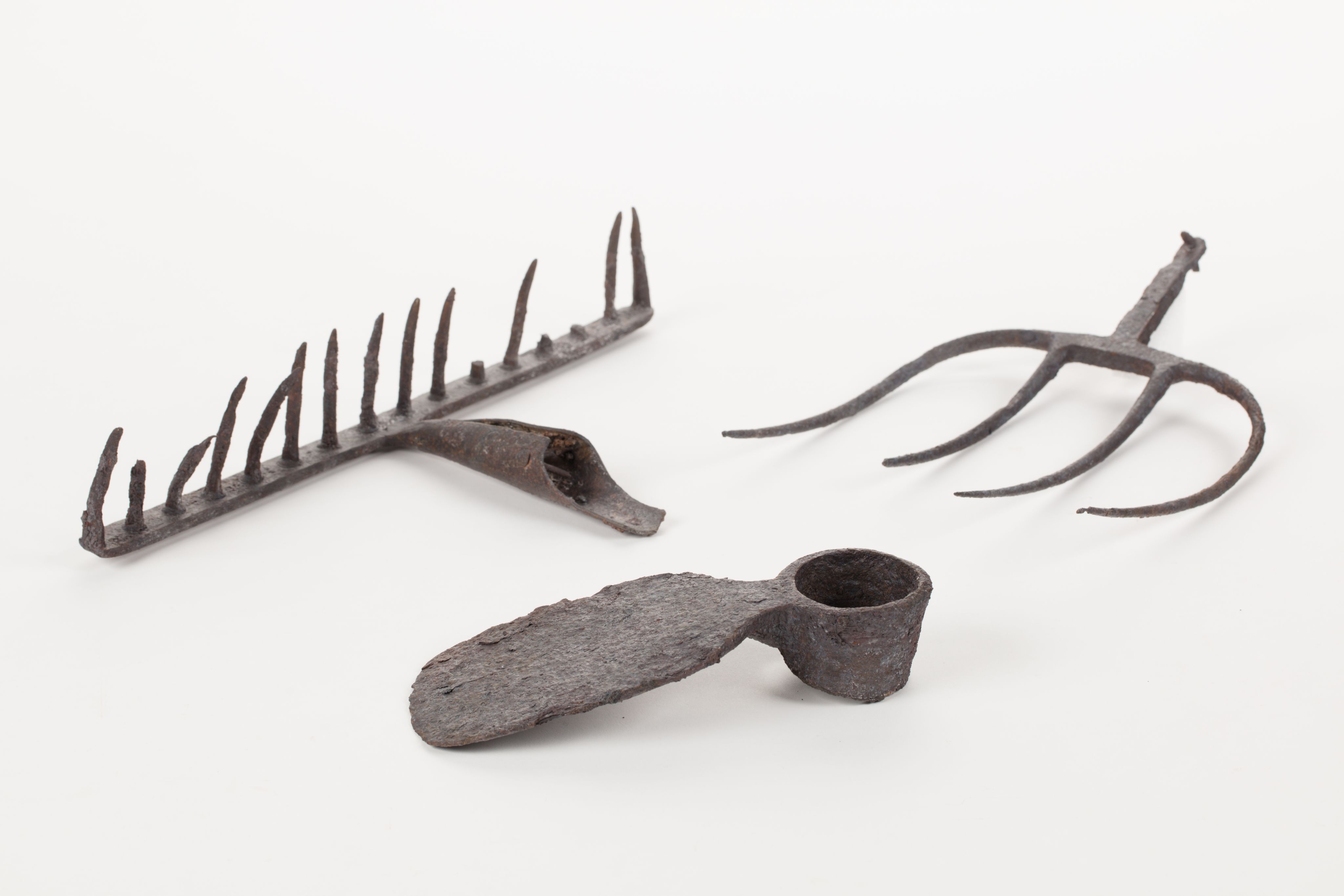 The image shows a white surface with a variety of gardening tools