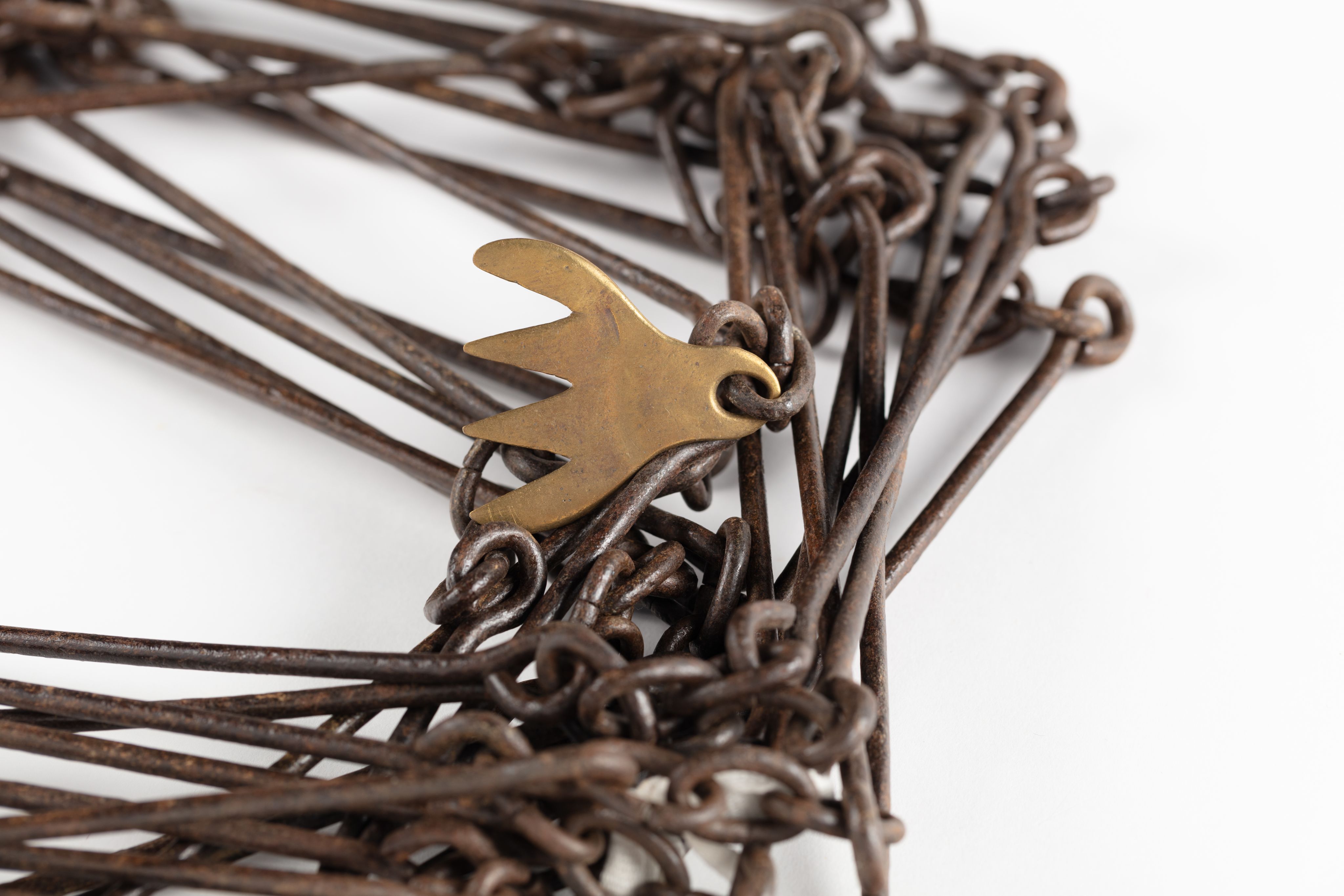 Surveyor's chain made from equally spaced steel links with brass markers in the form of one, two, three and four 'fingers'.
