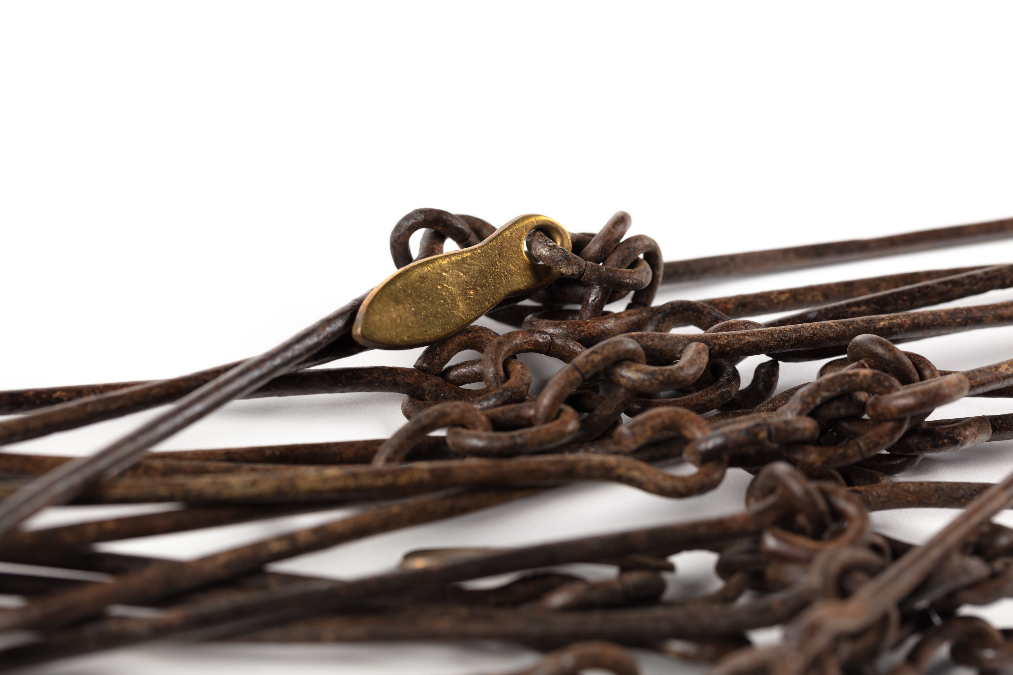 Surveyor's chain made from equally spaced steel links with brass markers in the form of one, two, three and four 'fingers'.