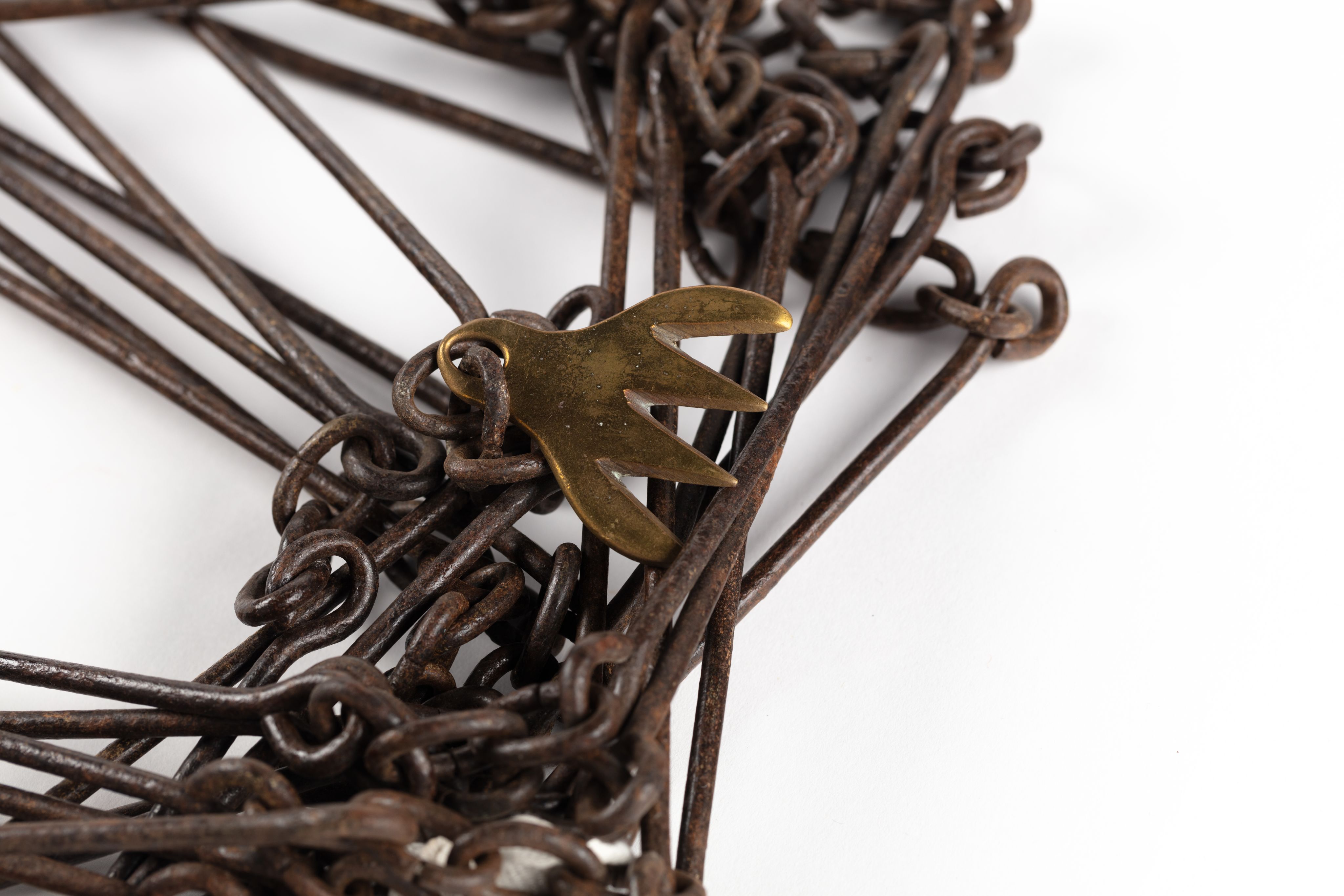 Surveyor's chain made from equally spaced steel links with brass markers in the form of one, two, three and four 'fingers'.