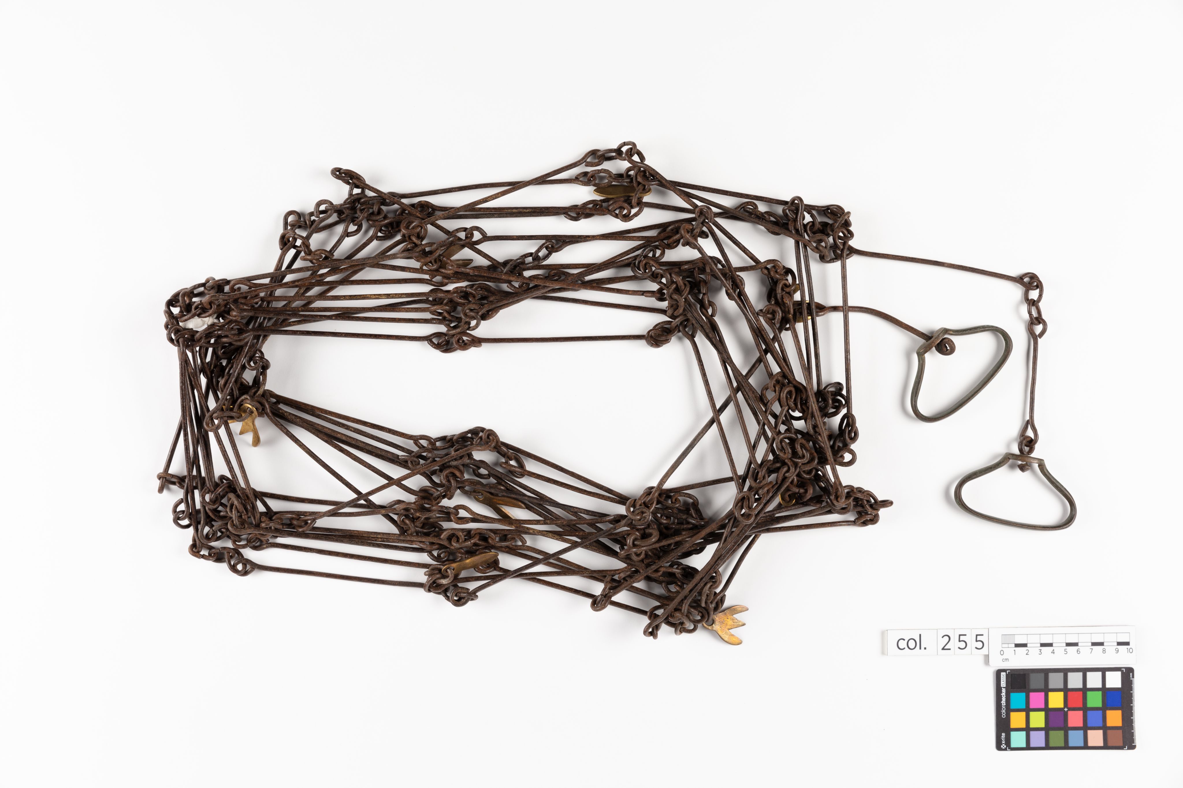 Surveyor's chain made from equally spaced steel links with brass markers in the form of one, two, three and four 'fingers'.