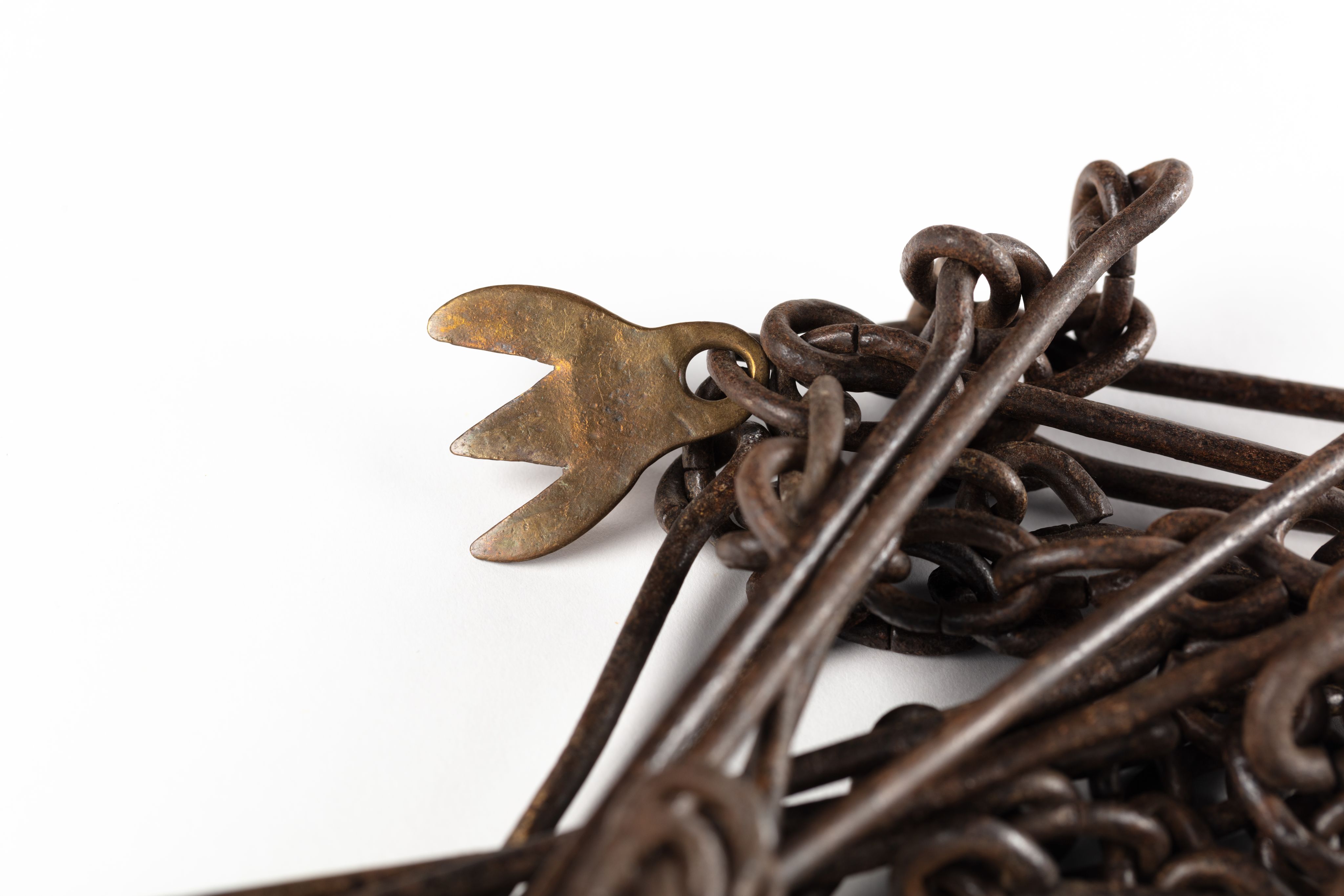 Surveyor's chain made from equally spaced steel links with brass markers in the form of one, two, three and four 'fingers'.