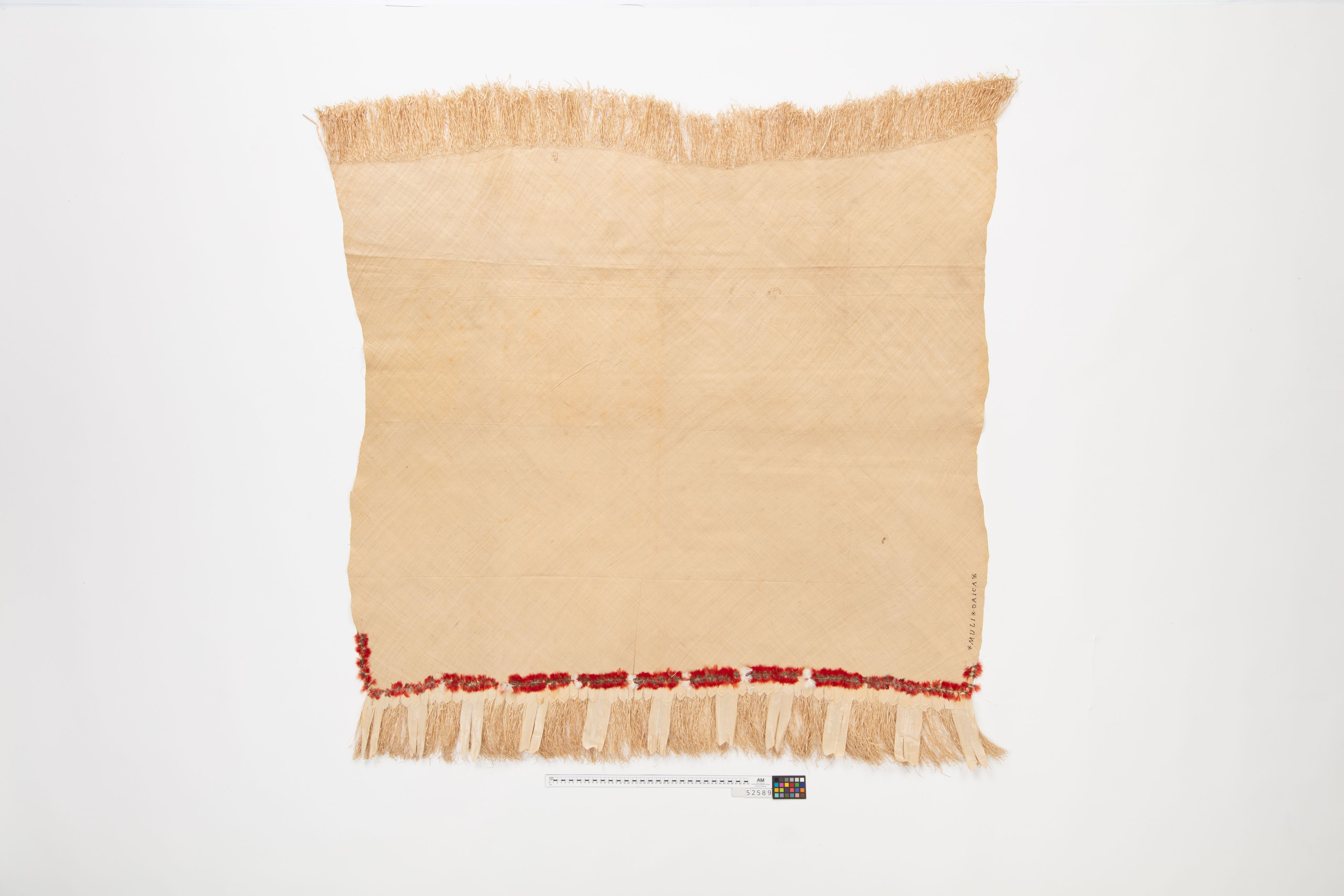 Fine mat made from pandanus (leaf) with "X MULI X OAIGA X" written the edge in ink. Red feathers are featured along the border of mat.