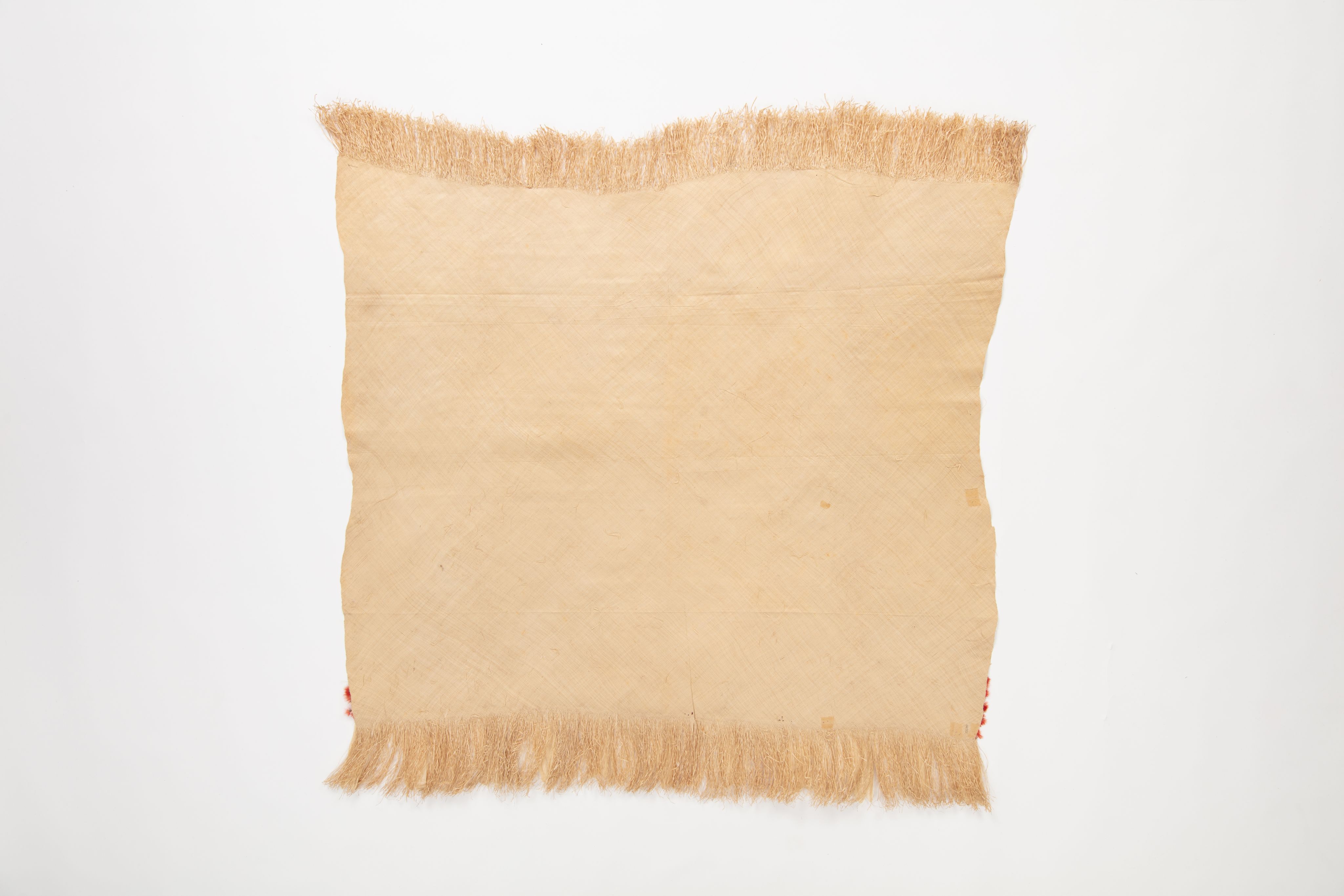 Fine mat made from pandanus (leaf) with "X MULI X OAIGA X" written the edge in ink. Red feathers are featured along the border of mat.