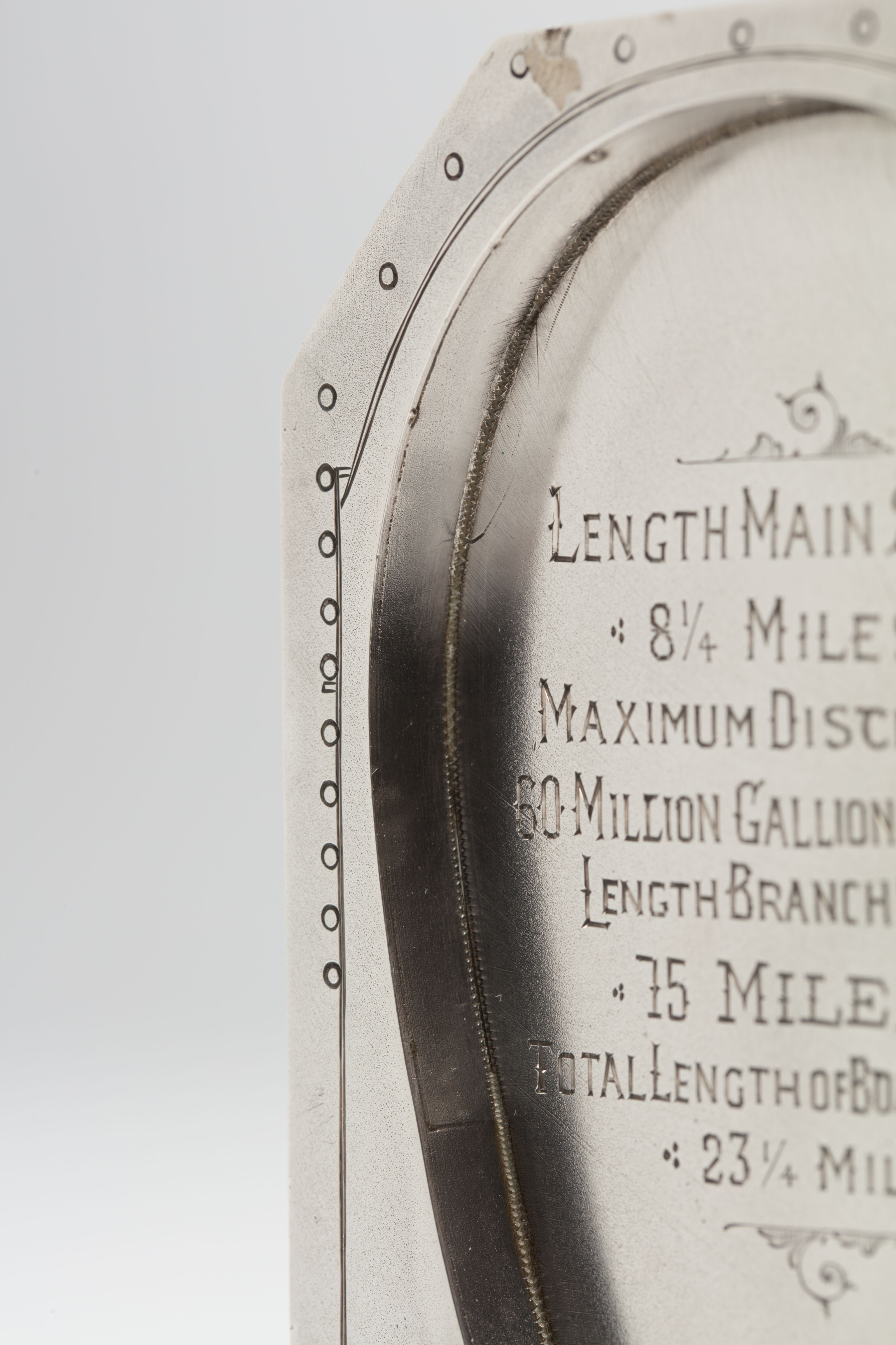 Finely crafted silver box (or casket) designed in the shape of the main sewage pipe, engraved with the names of the members of the drainage board along with technical sewage . On one side there is an engraved illustration of Ōkahu Bay, showing the Ngāti Whātua Ōrākei papakāinga and the newly installed sewer pipe running along the foreshore in front of it.