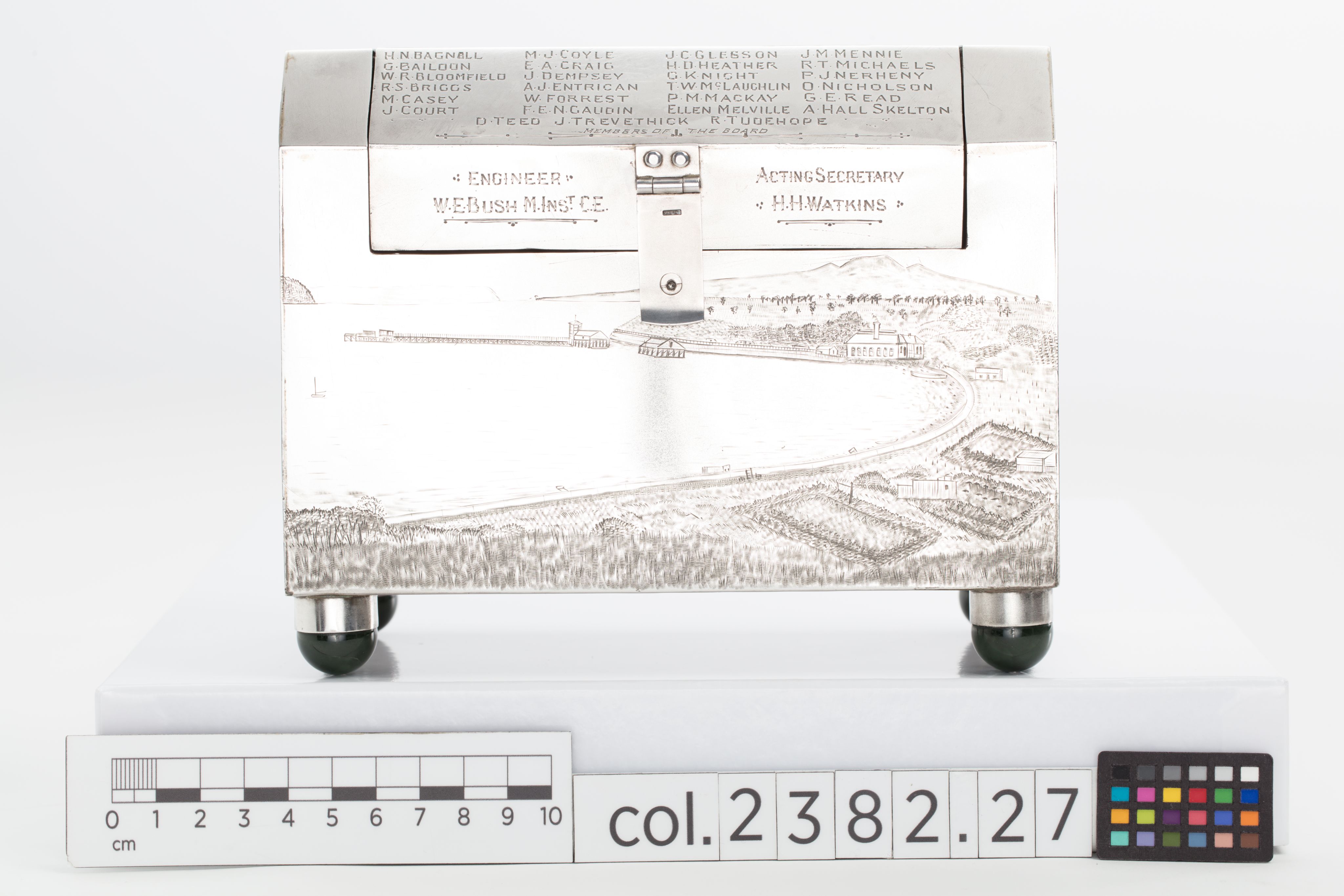 Finely crafted silver box (or casket) designed in the shape of the main sewage pipe, engraved with the names of the members of the drainage board along with technical sewage . On one side there is an engraved illustration of Ōkahu Bay, showing the Ngāti Whātua Ōrākei papakāinga and the newly installed sewer pipe running along the foreshore in front of it.