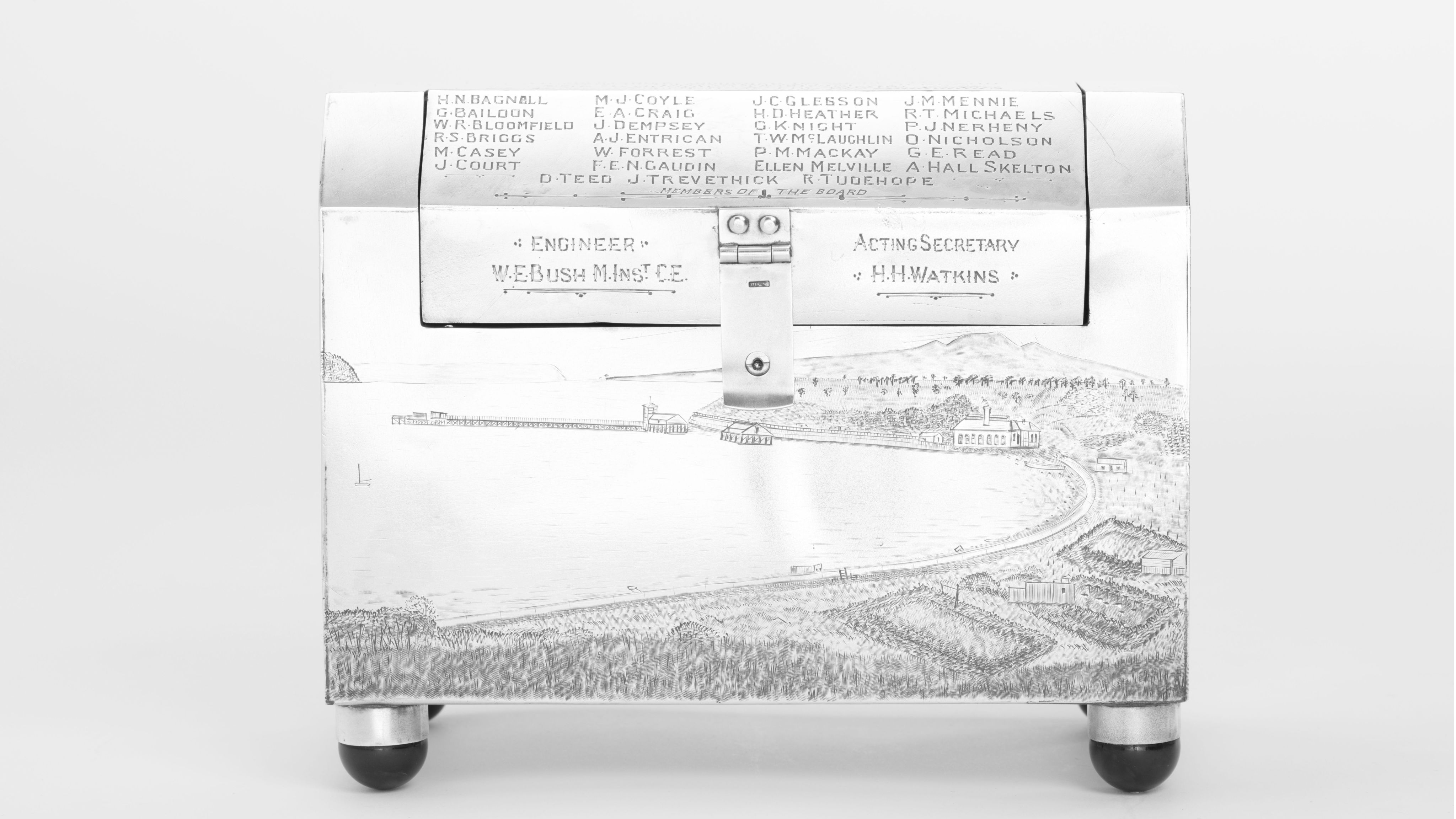 Finely crafted silver box (or casket) designed in the shape of the main sewage pipe, engraved with the names of the members of the drainage board along with technical sewage . On one side there is an engraved illustration of Ōkahu Bay, showing the Ngāti Whātua Ōrākei papakāinga and the newly installed sewer pipe running along the foreshore in front of it.