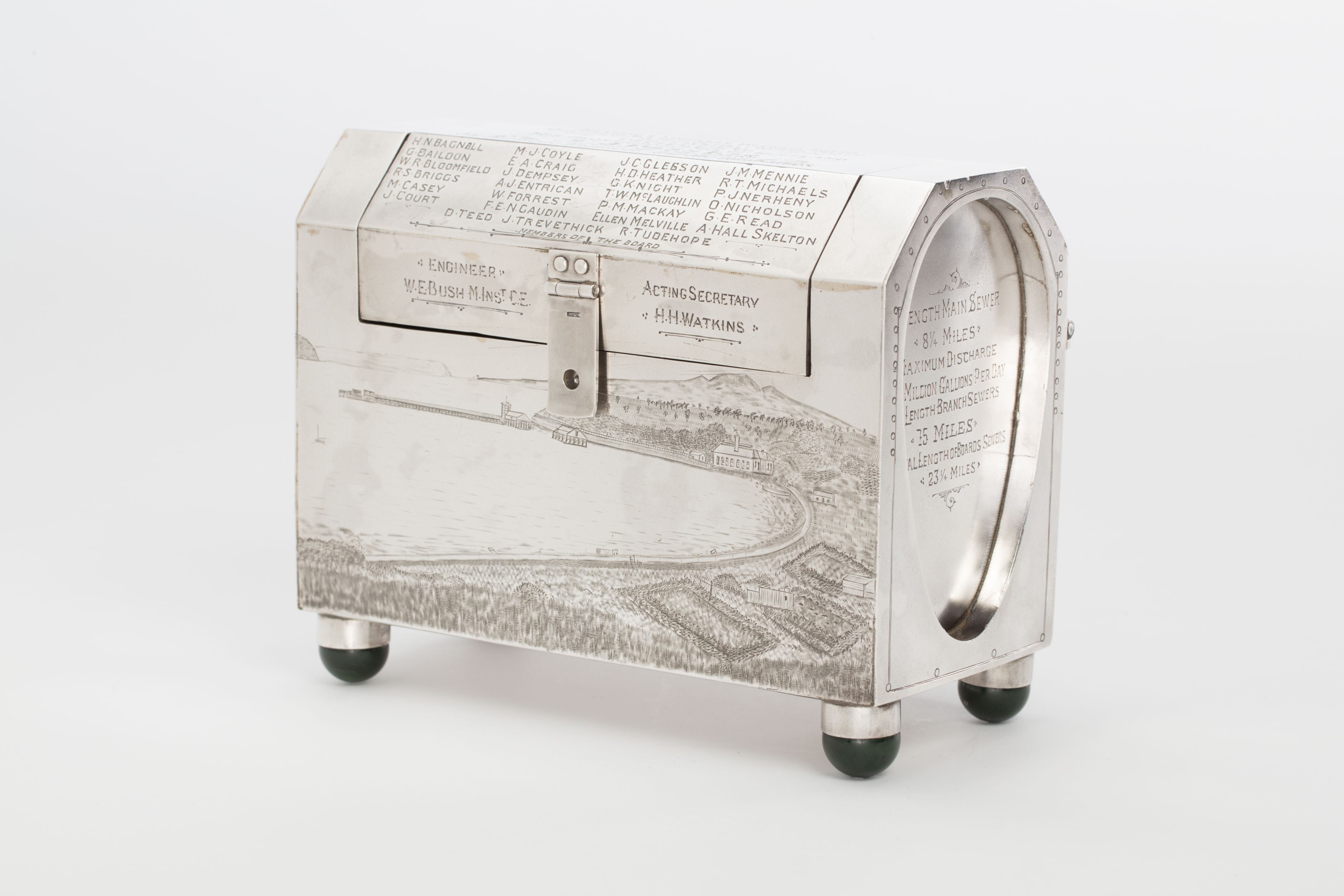 Finely crafted silver box (or casket) designed in the shape of the main sewage pipe, engraved with the names of the members of the drainage board along with technical sewage . On one side there is an engraved illustration of Ōkahu Bay, showing the Ngāti Whātua Ōrākei papakāinga and the newly installed sewer pipe running along the foreshore in front of it.